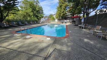 A swimming pool with chairs and a fence around it